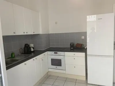 a kitchen with white cabinets and a sink and a refrigerator at Charmant 2 pièces - hypercentre, proche mer in Nice