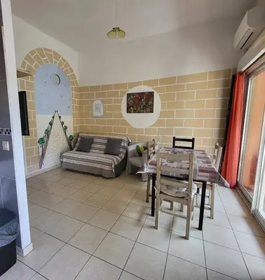 a living room with a couch and a table at Cœur d'azur in Saint-Laurent-du-Var