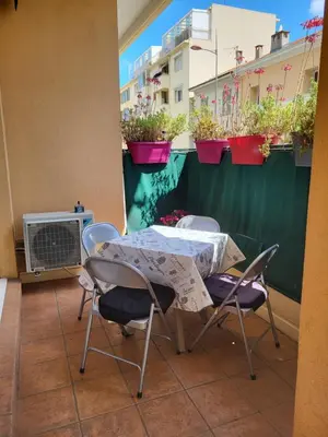 a table and chairs on a balcony with potted plants at Cœur d'azur in Saint-Laurent-du-Var