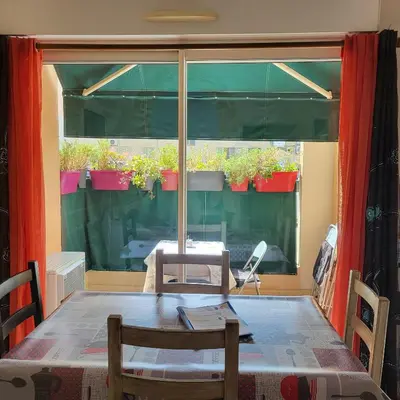 a dining room table with a view of a window at Cœur d'azur in Saint-Laurent-du-Var