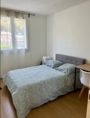 a bedroom with a bed and a desk and a window at Nice Apartement 20 mins from the beach in Nice