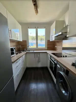 a kitchen with white cabinets and a washer and sink at Nice Apartement 20 mins from the beach in Nice