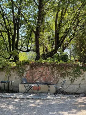 a table and two chairs sitting next to a wall at Studio en bas de villa avec piscine proche bord de mer in Cagnes-sur-Mer