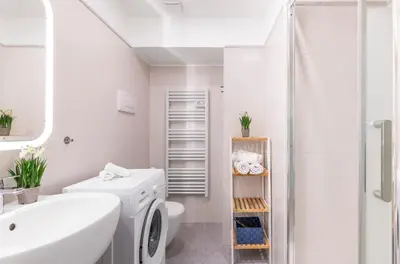 a white bathroom with a sink and a washing machine at AZUR Apartment - Quiet City Center Location by the Sea in Nice