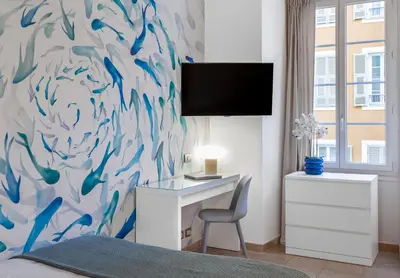 a bedroom with a desk and a painting of fishes at AZUR Apartment - Quiet City Center Location by the Sea in Nice
