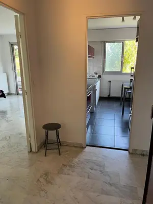 a kitchen with a table and a stool in a room at 2 pièces avec terrasse en résidence privée in Nice