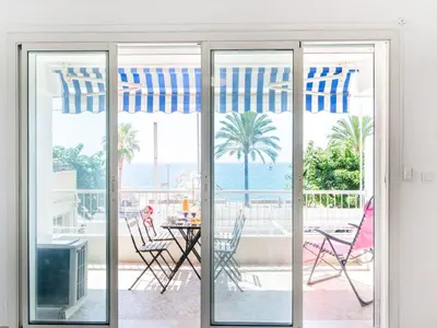 a sliding glass door with a view of the ocean at Apartment Les Trois Caps by Interhome in Cagnes-sur-Mer