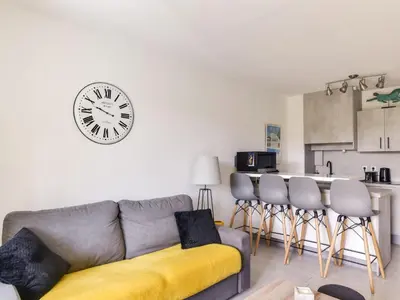 a living room with a couch and a clock on the wall at Apartment Cimiez Les Pins by Interhome in Nice