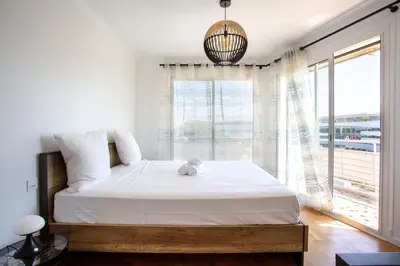 a bedroom with a bed and a large window at Apartment T2 air-conditioned sea view in Saint-Laurent-du-Var