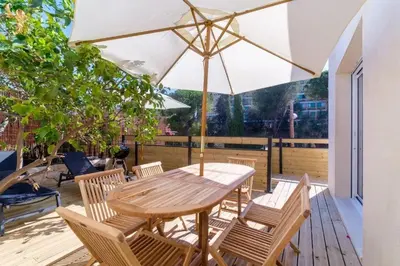 a wooden table and chairs with an umbrella on a deck at Magnifique pavillon indépendant T2 Nice in Nice