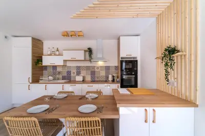 a kitchen with a wooden table and chairs at Magnifique pavillon indépendant T2 Nice in Nice