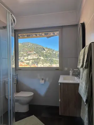 a bathroom with a window and a toilet and a sink at Excellent location - Sea Views in Villefranche-sur-Mer