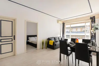 a living room with a dining room table and a couch at Suite Reine Marie FSHH in Nice