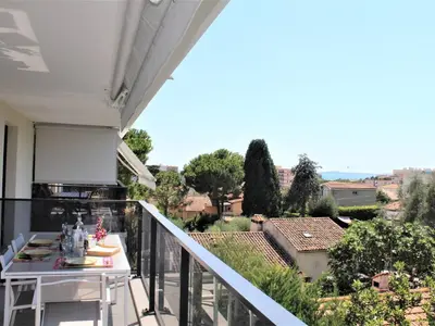 a balcony with a table and a view of a city at Appartement Neuf 3 Pièces avec Terrasse et Garage, Cagnes-sur-Mer - FR-1-252A-88 in Cagnes-sur-Mer