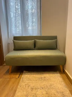 a green couch sitting in front of a window at Villa Niçoise.3P. 5 min de la plage in Nice
