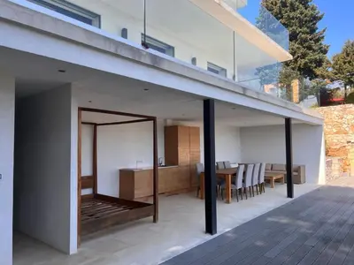 an open deck with a dining area and a house at Villa LA ALEGRIA in Nice