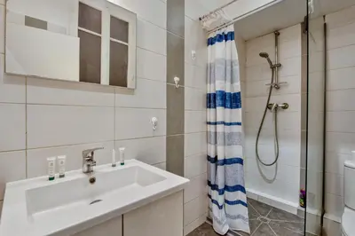 a bathroom with a sink and a shower at Appartement Oscarmony - Welkeys in Nice