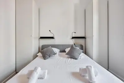a bedroom with a large white bed with mirrors at Appartement Oscarmony - Welkeys in Nice