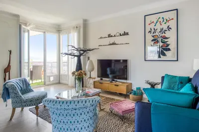 a living room with a blue couch and chairs at Appartement Ayres - Welkeys in Nice
