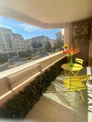 a balcony with a table and two chairs and a window at Appartement 6 pers Port de Nice, mer et Vieux-Nice à pied in Nice