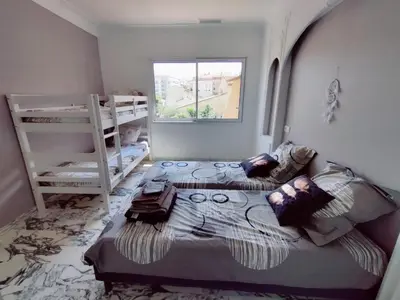 a bedroom with two bunk beds and a window at La Villa Castel - Haut de villa - parkings- 3 chambres - 8 couchages - jardin - barbecue in Cagnes-sur-Mer