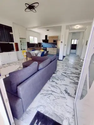 a living room with a blue couch and a marble floor at La Villa Castel - Haut de villa - parkings- 3 chambres - 8 couchages - jardin - barbecue in Cagnes-sur-Mer