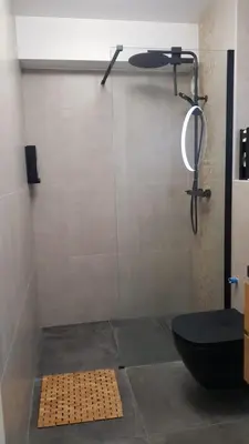 a bathroom with a shower with a toilet and a mirror at Nice Bel Appartement Vue Mer climatisé avec Grande Terrasse in Nice