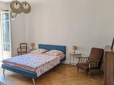 a bedroom with a bed and chairs in a room at Amazing 2-bedroom apartment in Nice near the beach in Nice