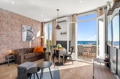 a living room with a couch and a brick wall at Nice Renting - CAMBRAI - Luxurious Sea View Terrasse - King Bed - Parking - AC - fully equipped in Nice