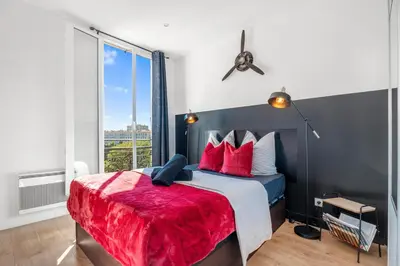 a bedroom with a bed with red pillows and a window at Nice Renting - CAMBRAI - Luxurious Sea View Terrasse - King Bed - Parking - AC - fully equipped in Nice