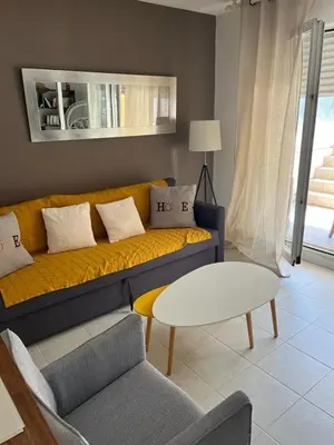 a living room with a yellow couch and a table at Ninon in Nice