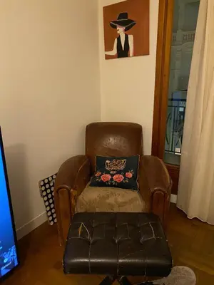 a brown leather chair with a pillow and a stool at I Love you Berry Berry Much! in Nice
