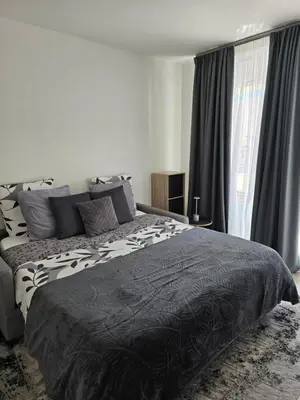a bedroom with a black and white bed and a window at Lovely 1 bedroom vacation home with free parking. in Nice
