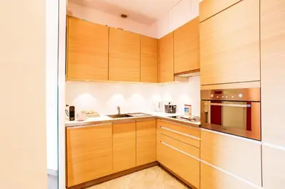 a kitchen with wooden cabinets and a sink at MASSENA AP4312 By Riviera Holiday Homes in Nice