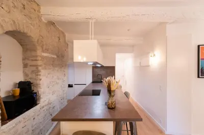 a kitchen with a table and a brick wall at Old Town Nice Renovated 2BR Near Beaches & Cours Saleya in Nice