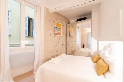 a bedroom with a white bed and a tub and a window at Old Town Nice Renovated 2BR Near Beaches & Cours Saleya in Nice