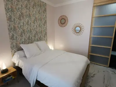 a bedroom with a white bed and a wall at Proche mer, vieille ville. Luxueux appartement in Villefranche-sur-Mer
