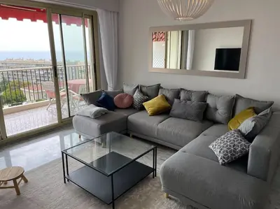 a living room with a couch and a glass table at Exceptional sea view, tennis, parking, WiFi in Nice