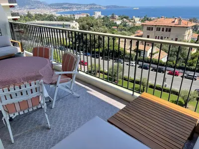 a balcony with a table and chairs and a view at Exceptional sea view, tennis, parking, WiFi in Nice