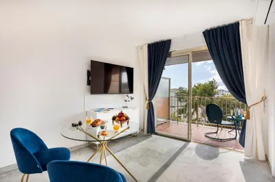 a living room with a glass table and blue chairs at BLUE LIGHT TERRACE - Nice Port in Nice