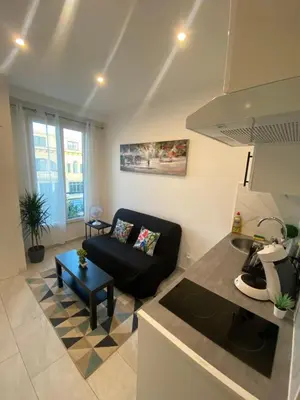 a living room with a couch and a table at Studio sur avenue jean médecin à Nice in Nice