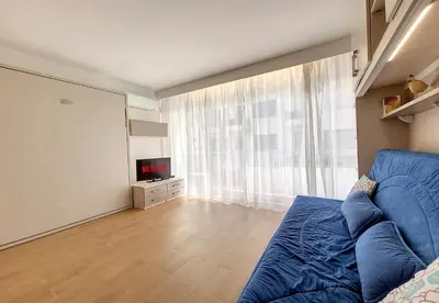 a living room with a blue couch and a tv at Nestor&Jeeves - THAIS BEACH - Central - Very close sea - Pedestrian zone in Nice