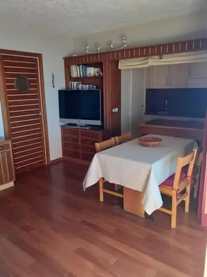 a dining room with a table and chairs and a tv at Maeva in Saint-Laurent-du-Var