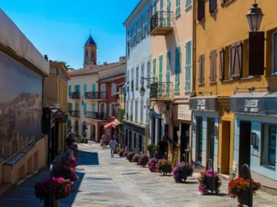 a street in a town with flowers on the sidewalk at 2P neuf au Coeur de St Jean Cap Ferrat in Saint-Jean-Cap-Ferrat