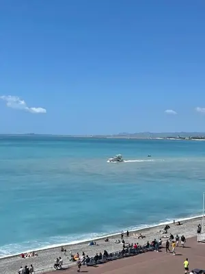 a group of people on a beach with a boat in the water at OPERA PROMENADE 4 Renovated 3 Bedrooms Balcony Sea View AC in Nice