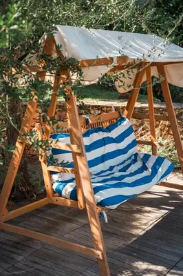 a wooden chair under an umbrella on a deck at Charming Villa Saint-Jean-Cap-Ferrat in Saint-Jean-Cap-Ferrat