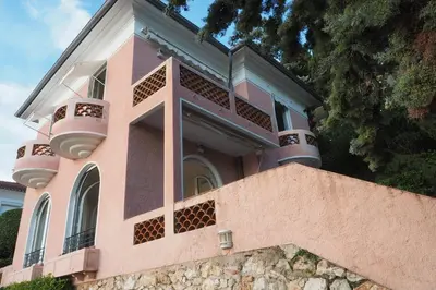 a pink house with balconies on top of a wall at Villa la Felicite in Saint-Jean-Cap-Ferrat