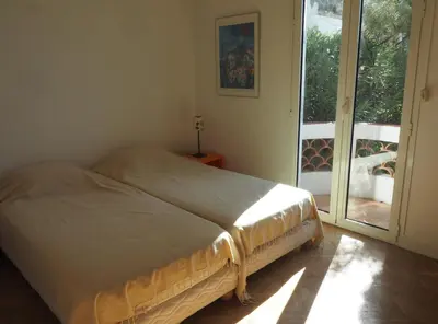 a bed sitting in a room with a window at Villa la Felicite in Saint-Jean-Cap-Ferrat
