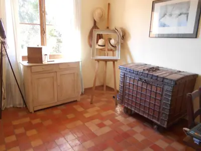 a room with a table and a dresser and a window at maison florentine in La Gaude