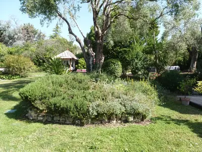 a garden with bushes and a gazebo at maison florentine in La Gaude